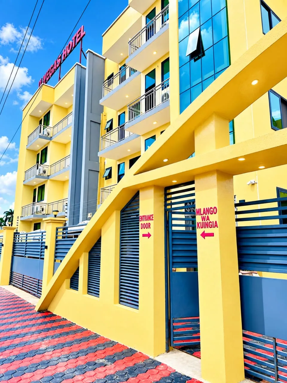 The yellow façade and entrance gate of Vegas Luxury Hotel